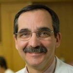 Head shot of a man with glasses and a mustache